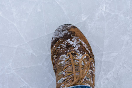 Men boots on cracked ice. Winter concept