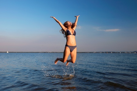young woman on the sky and water backgroundの写真素材