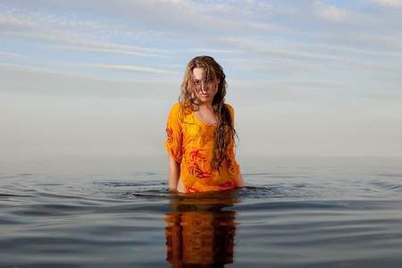 girl posing in the Water at sunsetの写真素材