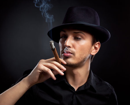 Gangster look. Man with hat and cigar. の写真素材