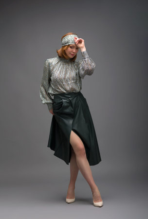 full length portrait of a fashionable aged woman isolated on gray background