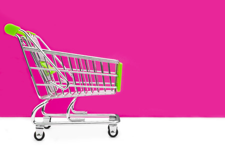 Cart from the grocery store on a pink background. Retail trade and advertising. Purchase in the store.の写真素材