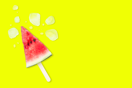 Slice of watermelon with ice cubes on a yellow background. Ice cream with the taste of watermelon. Sweet dessert. The summer mood.の写真素材