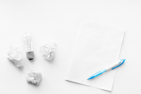 New business idea and innovation in trade. The concept of selling and buying. Pen, blank sheet and crumpled sheets of paper on the wooden white background. Writing poetry. Never give up.の写真素材