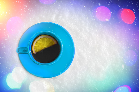 Mug of hot tea with a slice of lemon. Picturesque winter composition on the snow.の写真素材