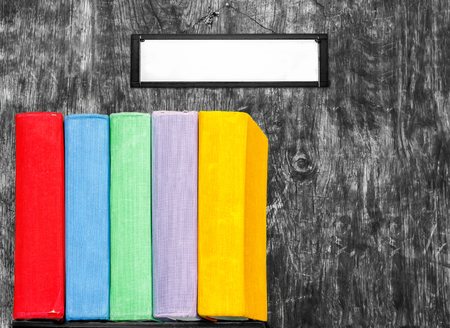 Books on the old wooden background. Multi-colored textbooks on the shelf. Concept: back to school, education.の写真素材