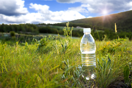 bottle of cold water on the grassの写真素材
