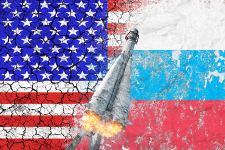 Confrontation between the USA and Russia. Threat of nuclear strike. The flags of two countries painted on the concrete wall. Arms race.の写真素材
