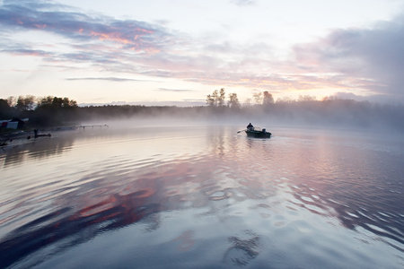 Morning nature scene (landscape): sky, clouds and fog (mist) and lonely boat reflected on the water...
