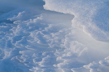 Winter abstract textured winter / backdrop with snow pattern in white and blue illuminated by sun...