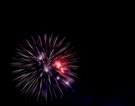 Colorful firework sparkles pattern against dark sky background.の写真素材