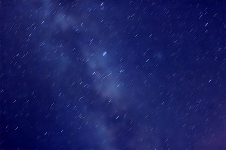 Astronomy universe space image - pattern of star trails with blurred Milky Way as a background.