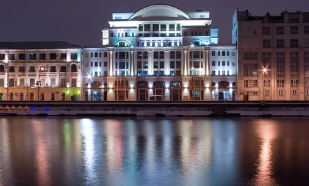 Moscow, Moskov river embankment by a winter night with river and streetligt reflection as a foreground, illuminated historical building as a main subject and cloudy sky as a background. Landscape orientation.の写真素材