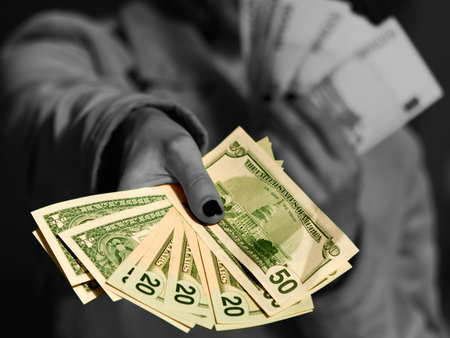 Black and white woman giving some amount of colorful  money (dollars) as an allegory of grey...