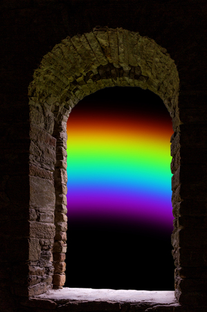 Rainbow on black dark sky visible through old ancient stone window.の写真素材