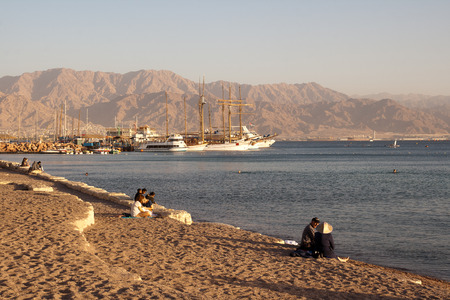 Eilat, Israel - December 12, 2011: View on the beach, illuminated by the rays of the setting sun. Gulf of Aqaba, Red sea.のeditorial素材