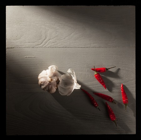 Garlic and red pepper on stone slate plateの写真素材