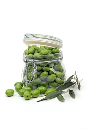 Green olives in a jar, isolated on whiteの写真素材