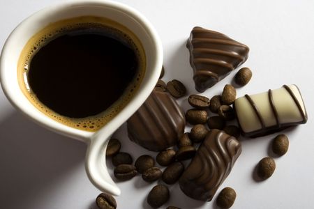 Coffee cup and chocolate candies on white backgroundの写真素材