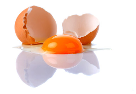 Broken egg with yolk isolated on white background