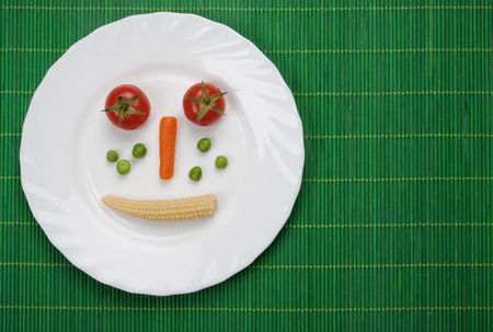 Tomato carrot peas and corn served on a plateの写真素材