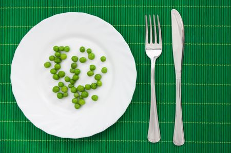 Green peas served on a white plateの写真素材