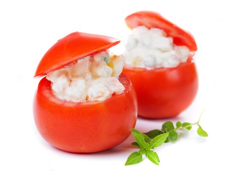 Fresh tomato stuffed with cream sauce and vegetables isolated on whiteの写真素材