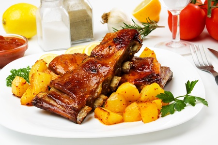 Honey glazed barbecued ribs with baked potatoの写真素材
