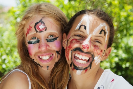 Two young girls with faces painted for carnival paradeの写真素材