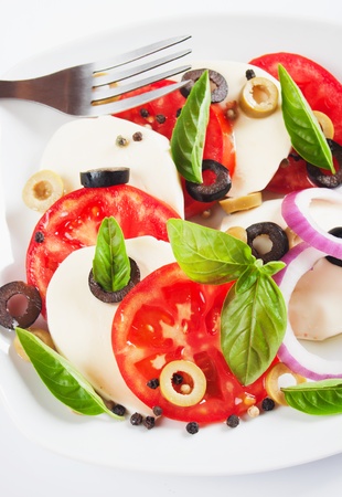 Caprese salad with tomato, basil, olives and mozzarella cheeseの写真素材