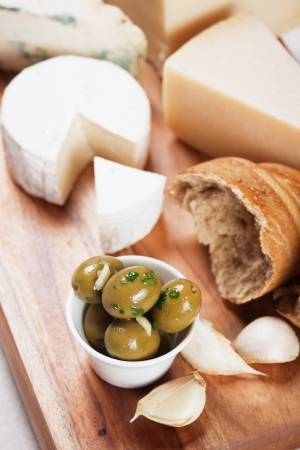 Pickled green olives with cheese, bread and garlicの写真素材
