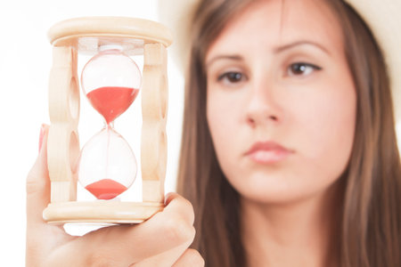 Time passing concept, woman looking at sandclock