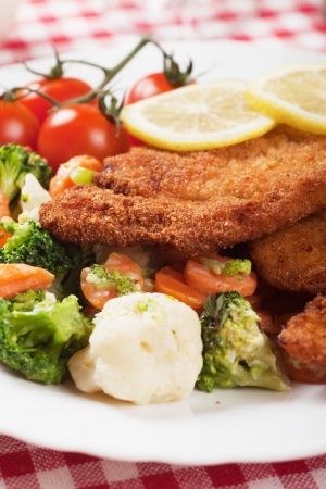 Viener schnitzel, breaded steak with broccoli, caulifolwer and carrotの写真素材