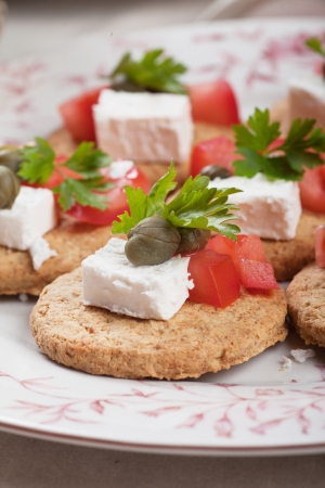 Canape with feta cheese, caper and cherry tomatoの写真素材