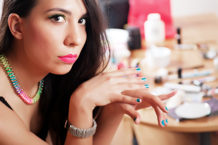 Beautiful young girl putting make-up, studio shootの写真素材