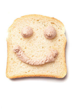 Happy smiley pÃ¢tÃ© spread, slice of bread isolated on whiteの写真素材