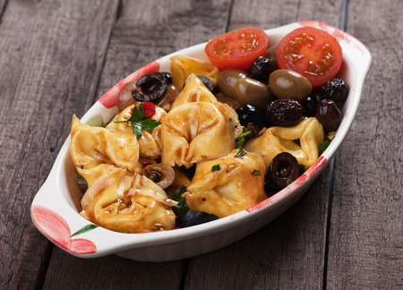 Italian tortellini pasta in tomato and olive sauceの写真素材
