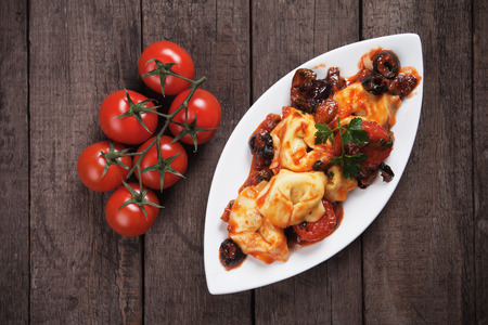 Italian tortellini pasta in tomato and olive sauceの写真素材