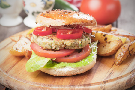Vegan burger with tomato and lettuce, healthy vegetarian version of classic american fast foodの写真素材