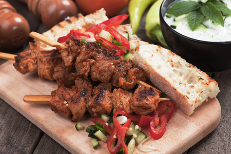 Souvlaki or kebab, meat skewer with toasted bread and fresh vegetableの写真素材