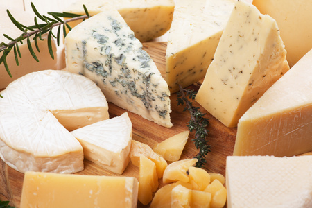 Assorted cheese on wooden platter, rich and healthy breakfast or snack foodの写真素材