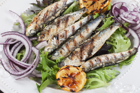 Grilled sardine fish with lettuce, lemon and onionの写真素材