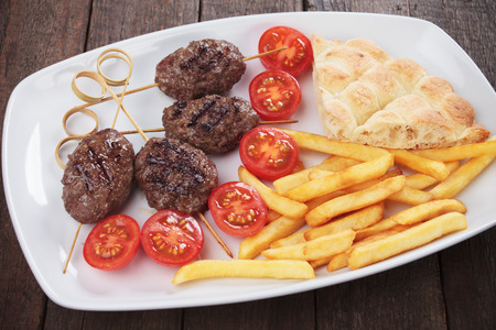 Kofta kebab, turkish minced meat skewer with pita bread and french friesの写真素材