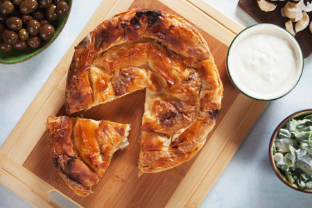 Phyllo pastry cheese pie served with yoghurt, salad and olives