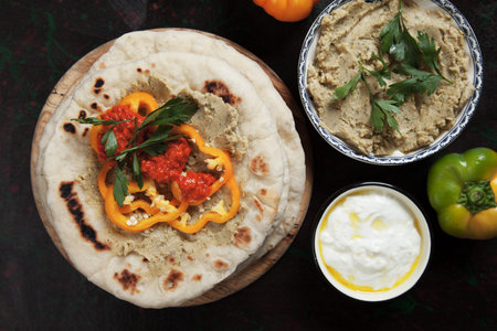 Pita bread, turkish or lebanese flatbread with hummus and pepper relish
