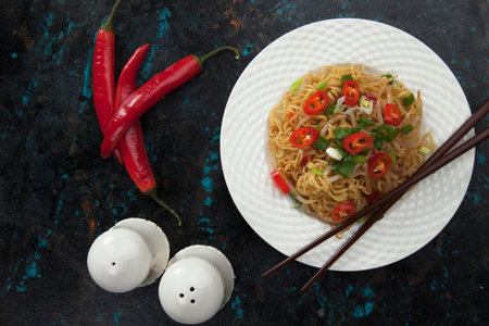 Asian noodles with bean sprouts, green onion and chili pepper