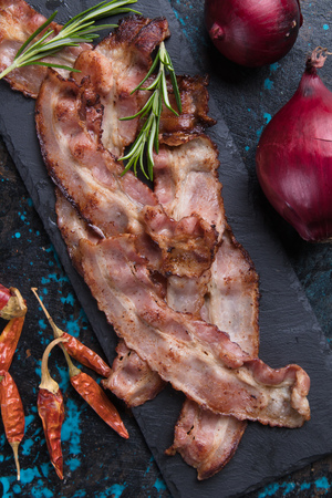 Slices of tasty smoked and fried bacon served as snack or breakfastの写真素材