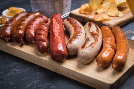 Grilled german sausages with mustard and fried potato chips