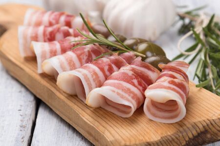 Rolls of pancetta bacon served with pickled olives, popular antipasto foodの写真素材