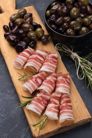 Rolls of pancetta bacon served with pickled olives, popular antipasto foodの写真素材